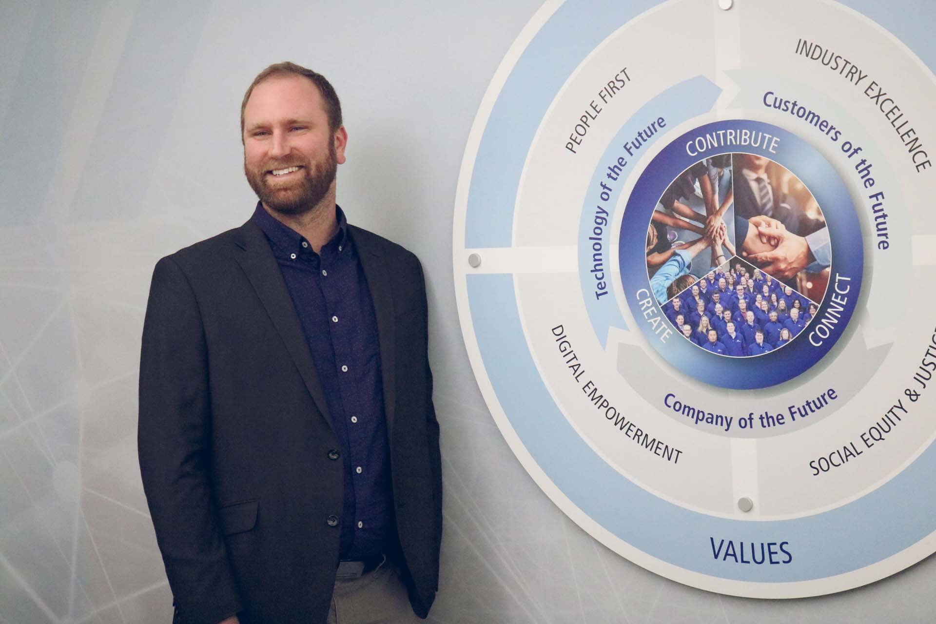 Stanley Consultants member standing near company values display