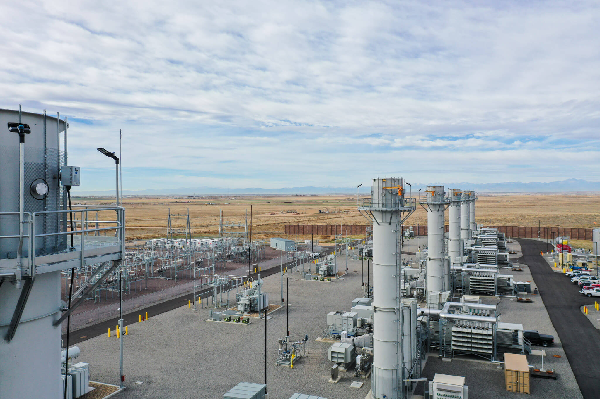 Photograph of Mountain Peak Power natural gas peaker facility in Keenesburg, Colorado, showing combustion turbine stacks, generation equipment and switchgear.