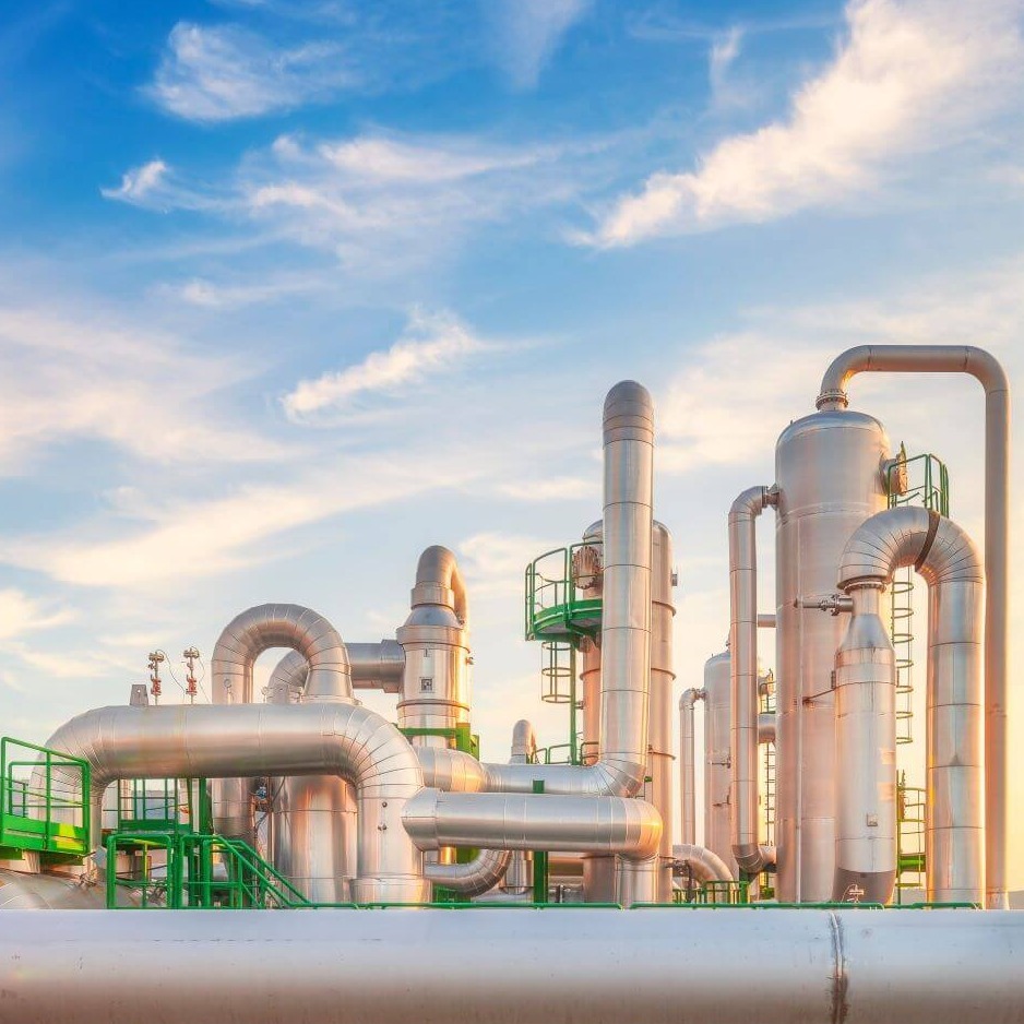 Geothermal energy facility with metal pipes and towers generating renewable power at sunset in a rural landscape