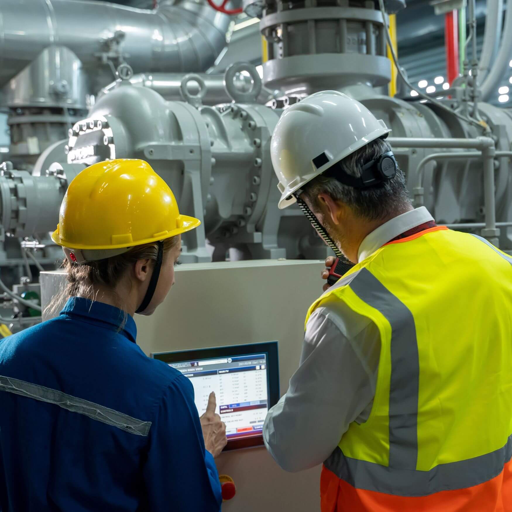 Commissioning engineers reviewing system data at an industrial plant control panel