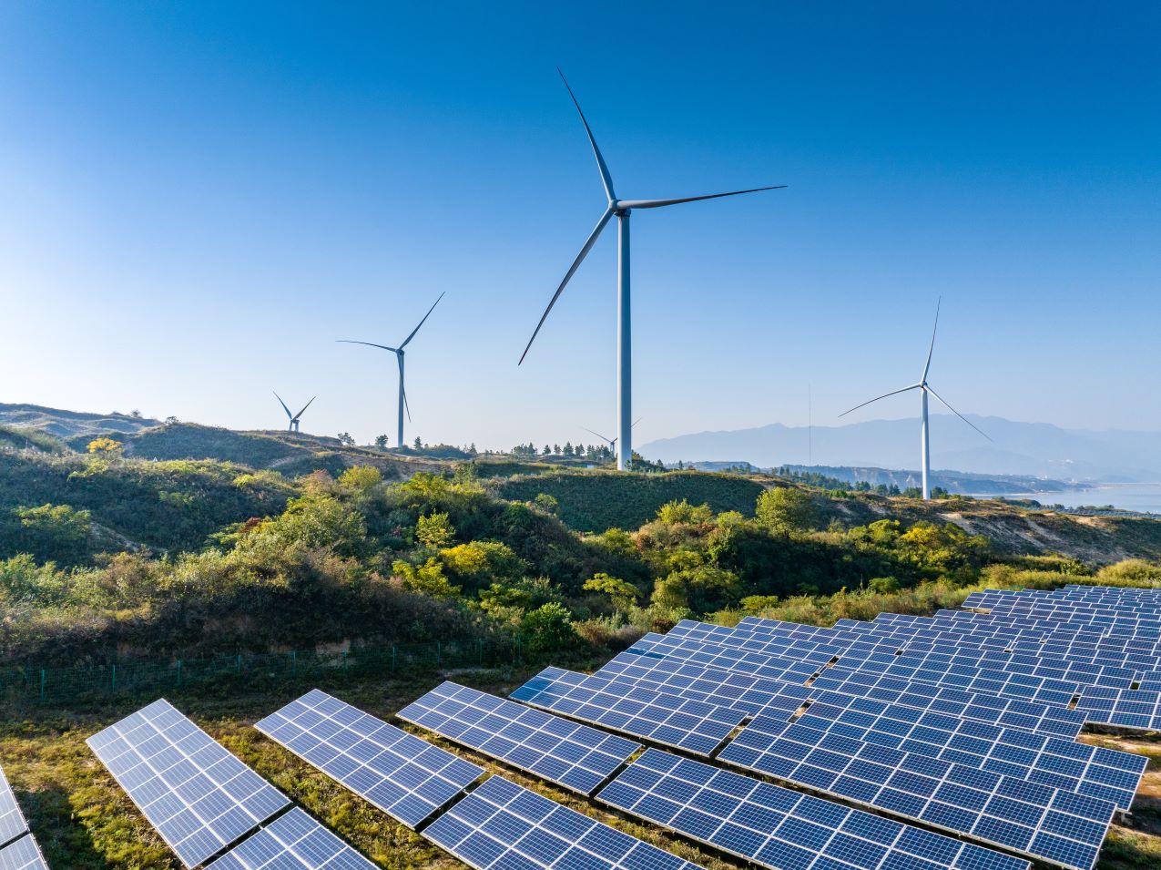 Solar panels and wind turbines in a mountain setting