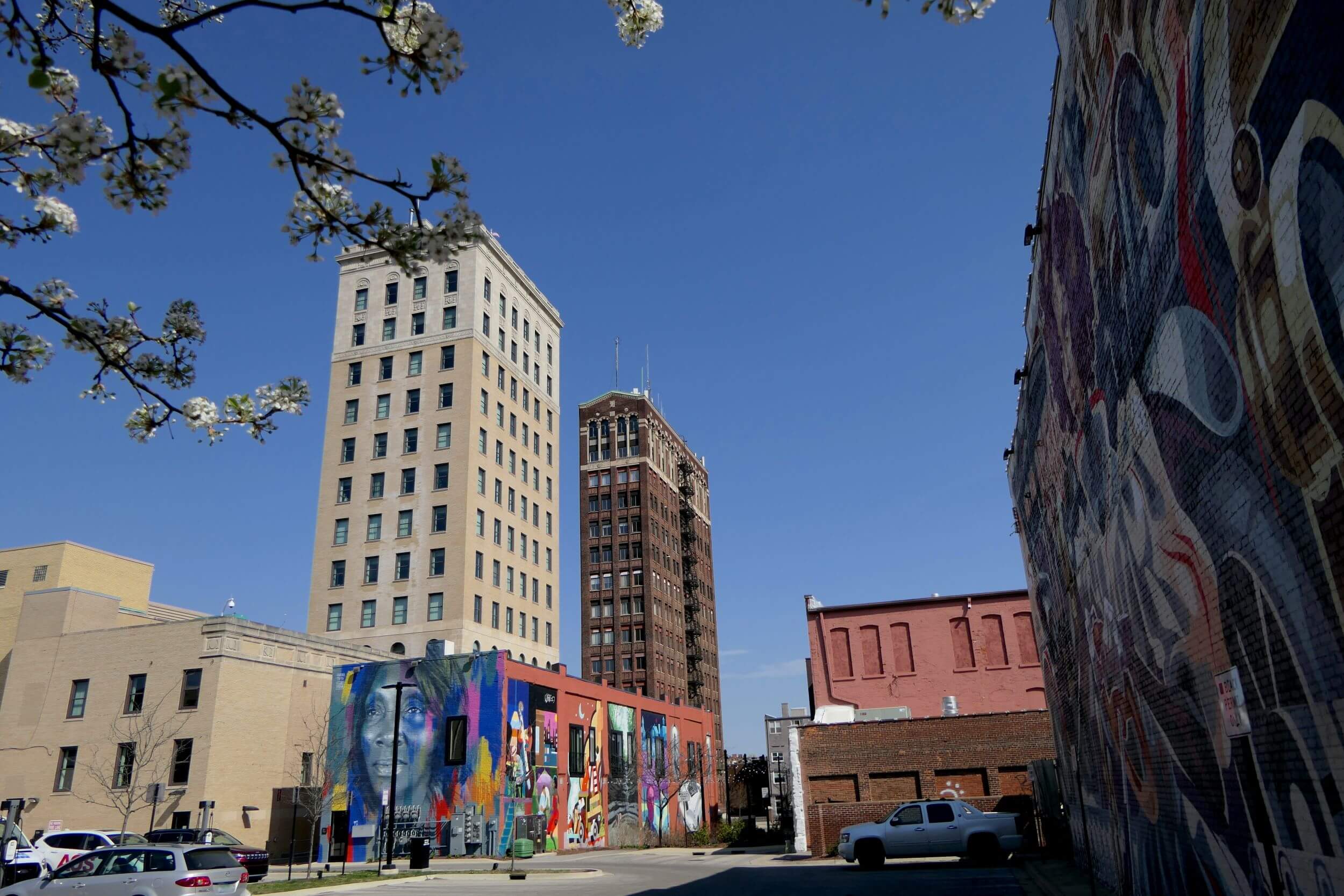 Street view of downtown Jackson, Michigan, featuring historic buildings, colorful murals, and a clear blue sky. Street view of downtown Jackson, Michigan, featuring historic buildings, colorful murals, and a clear blue sky.